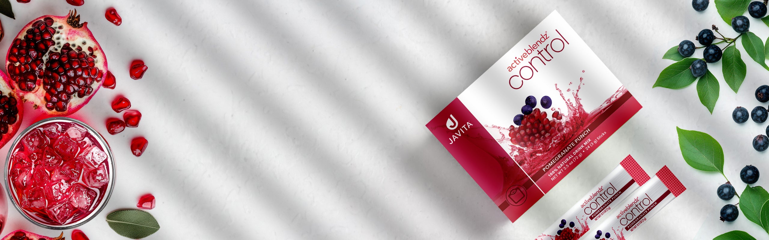 Box of Javita Control with 2 sticks, glass of pomegranate juice, Pomegranate fruits and Acai berries.
